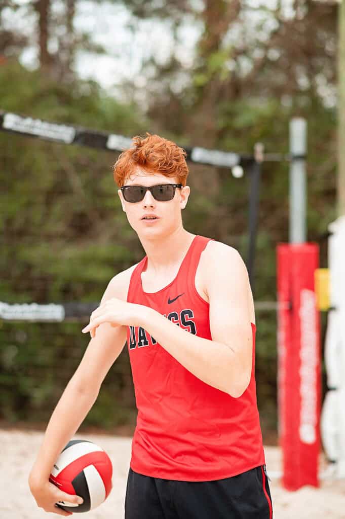 senior guy with sunglasses playing beach volleyball