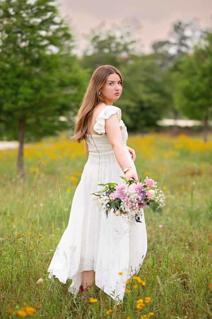 senior girl on a field with flowers